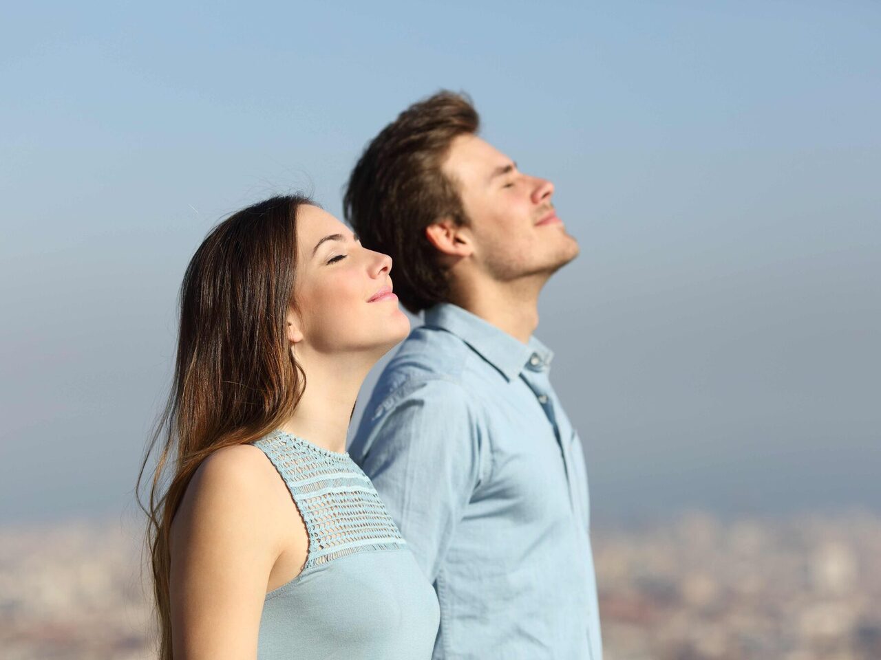 Seitenansicht eines Paares, das frische Luft atmet, mir urbanem Hintergrund