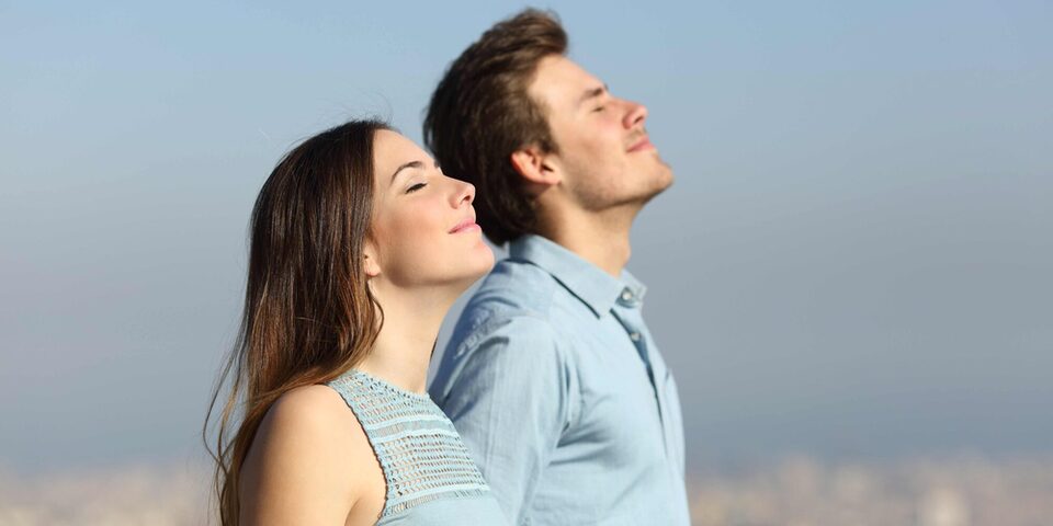 Seitenansicht eines Paares, das frische Luft atmet, mir urbanem Hintergrund