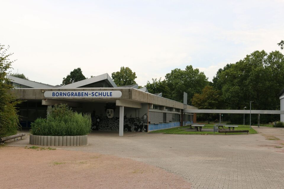 Frontalansicht der Borngraben-Schule mit Blick auf das Schulgebäude und den Schulhof nebenan.