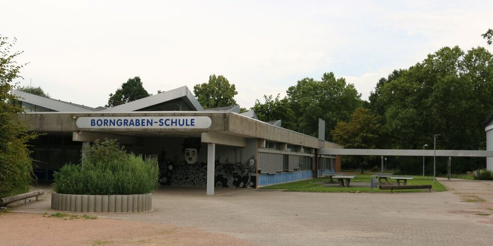 Frontalansicht der Borngraben-Schule mit Blick auf das Schulgebäude und den Schulhof nebenan.