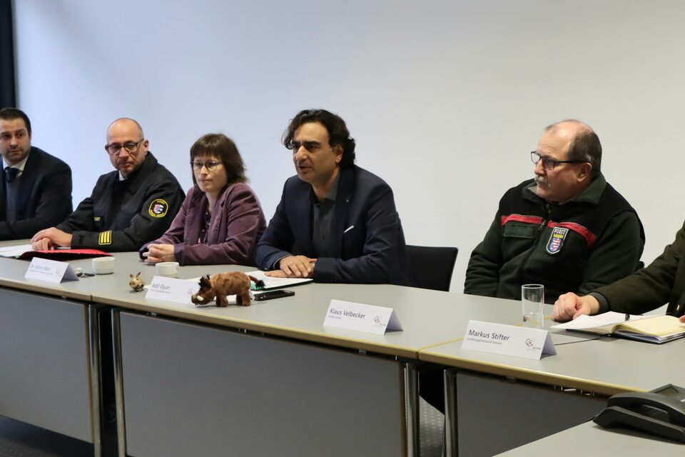 Vertreter des Kreises sitzen zur Pressekonferenz an einem langen Tisch