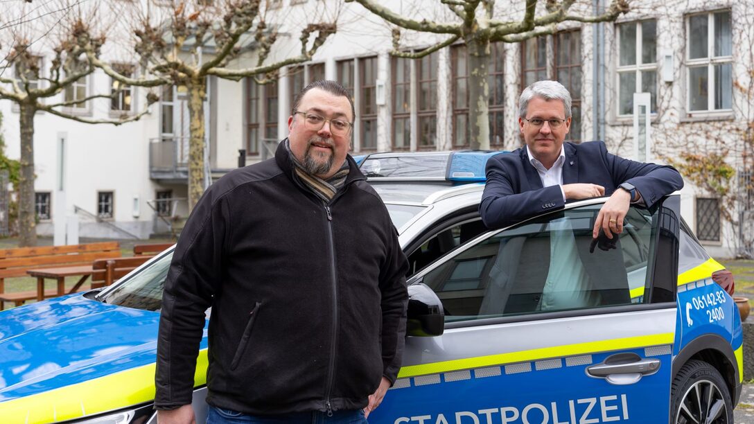 Oliver Hiß, Fachbereichsleiter Sicherheit und Ordnung, und Oberbürgermeister Patrick Burghardt stehen an Stadtpolizei-Auto im Rathaus-Innenhof.