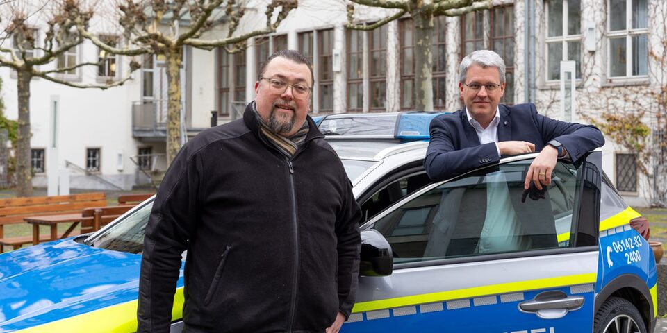 Oliver Hiß, Fachbereichsleiter Sicherheit und Ordnung, und Oberbürgermeister Patrick Burghardt stehen an Stadtpolizei-Auto im Rathaus-Innenhof.