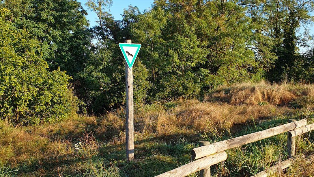 Ein Schild an der Sanddüne weist auf das Naturschutzgebiet hin