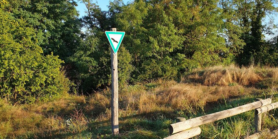 Ein Schild an der Sanddüne weist auf das Naturschutzgebiet hin