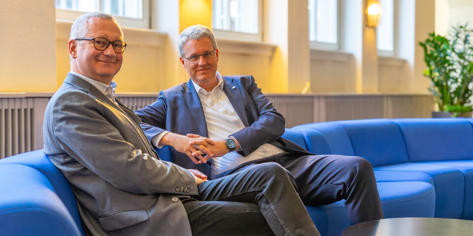 Geschäftsführer Regenstein und Oberbürgermeister Burghardt sitzen auf einem Sofa.