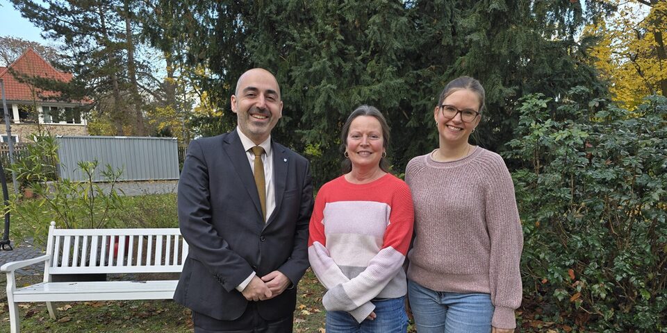 Drei Personen stehen im Garten des Haus der Senioren