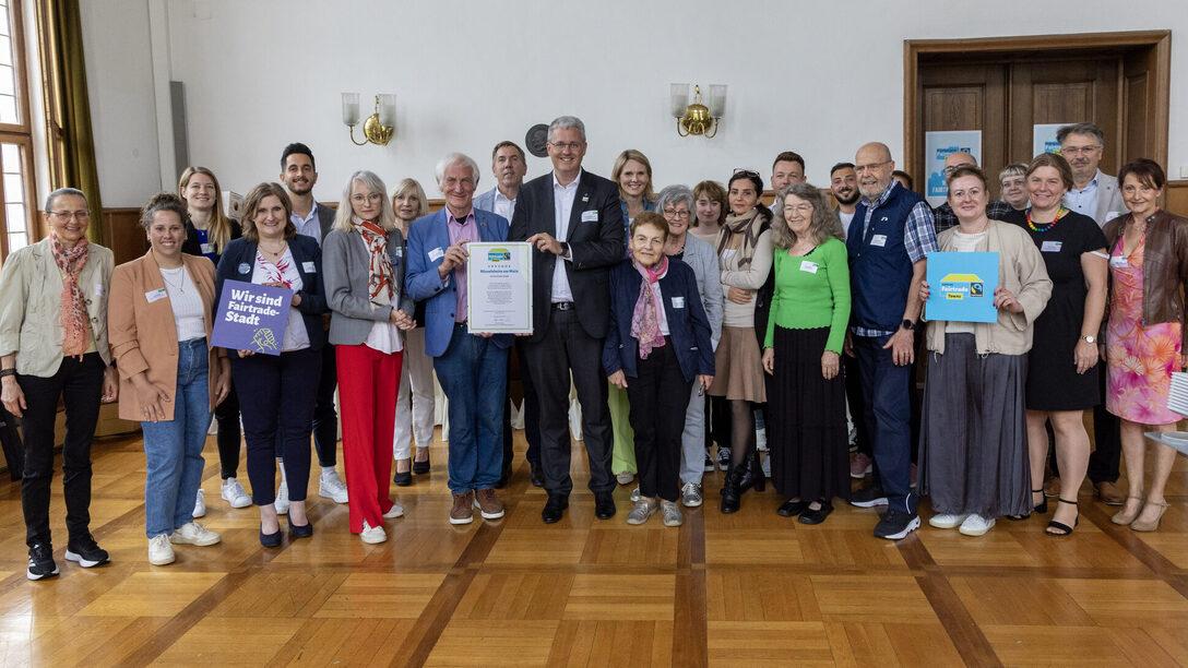 Oberbürgermeister Patrick Burghardt (1. Reihe, 6. von rechts) und Manfred Holz, Ehrenbotschafter von Fairtrade Deutschland e.V. (1. Reihe, 5. von rechts) sowie Mitarbeiterinnen, Mitarbeiter, Unterstützerinnen und Unterstützer die zur Zertifizierung der Stadt als Fairtrade Town beigetragen haben