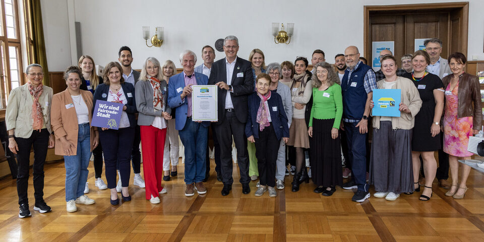 Oberbürgermeister Patrick Burghardt (1. Reihe, 6. von rechts) und Manfred Holz, Ehrenbotschafter von Fairtrade Deutschland e.V. (1. Reihe, 5. von rechts) sowie Mitarbeiterinnen, Mitarbeiter, Unterstützerinnen und Unterstützer die zur Zertifizierung der Stadt als Fairtrade Town beigetragen haben