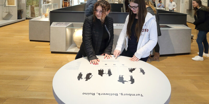 Zwei Personen stehen vor einer Informationstafel im Stadt- und Industriemuseum Rüsselsheim