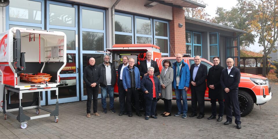 Magistratsmitglieder stehen auf dem Gelände der Feuerwache vor einem Feuerwehrauto