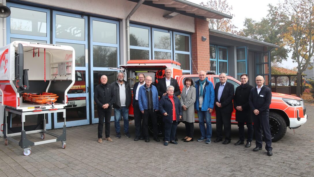 Magistratsmitglieder stehen auf dem Gelände der Feuerwache vor einem Feuerwehrauto