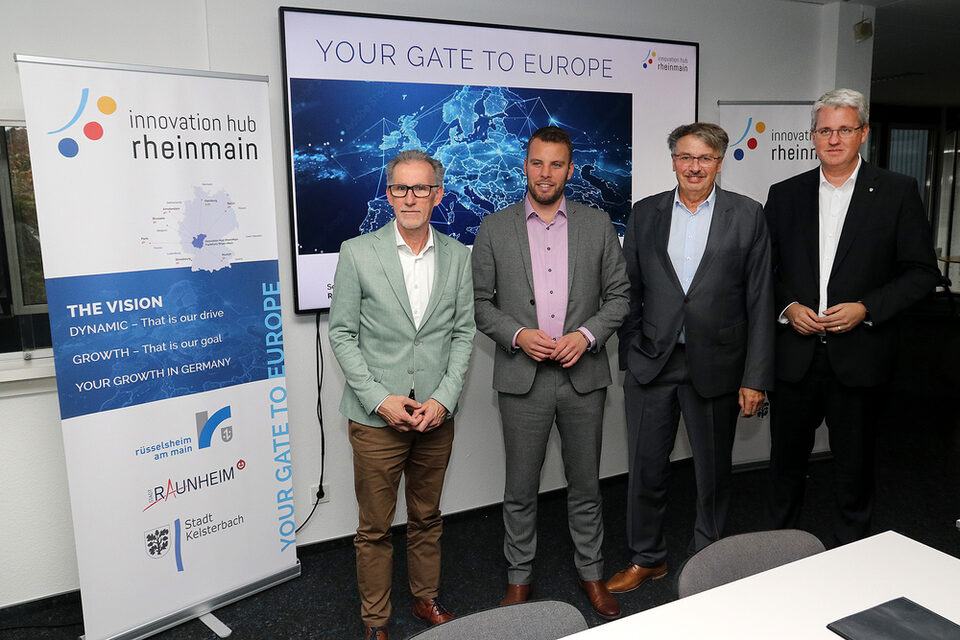 Stephan Wittekind, David Rendel, Manfred Ockel und Oberbüergemeister Patrick Burghardt stehen vor Präsentation mit dem Titel "Your gate to europe"