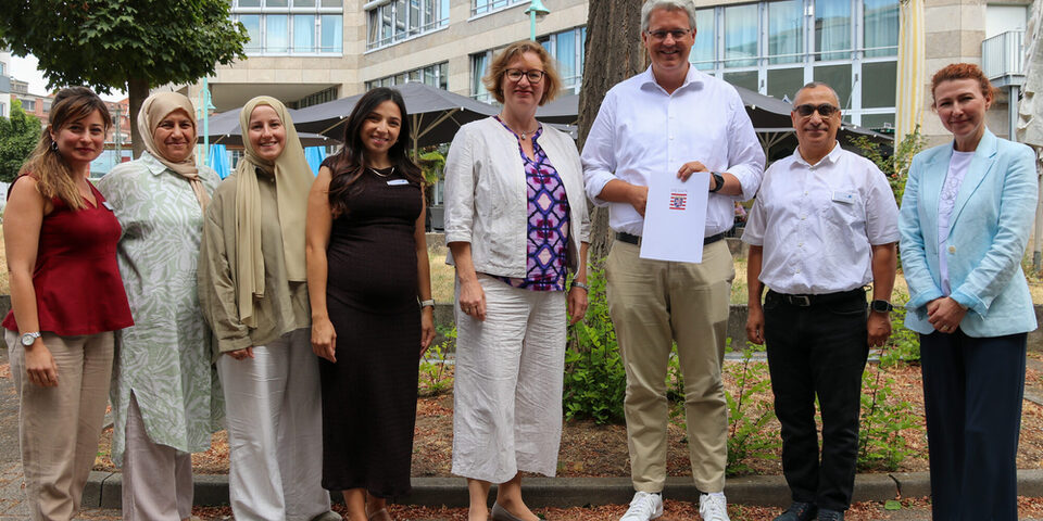 v.l.n.r.: Elena Pisapia (WIR-Koordinatorin), Bahia Bakkali (Integrations- und Gesundheitslotsin), Merve Türk (Gesundheitslotsin), Marina Saturno (WIR-Koordinatorin), STS Katrin Hechler, OB Patrick Burghardt, Mostafa Lyazami (Integrationsbeauftragter Stadt Rüsselsheim) und Galina Kalugina (Gesundheitslotsin)