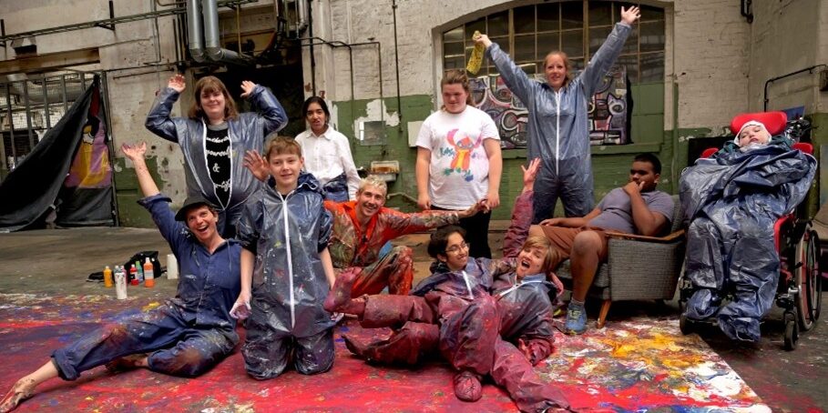 Gruppenbild von Schülerinnen und Schülern in Maleranzügen welches ihr Kunstprojekt vorstellen.