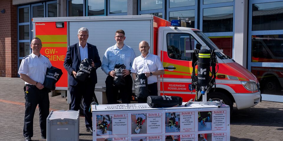 Oberbürgermeister Patrick Burghardt mit drei Feuerwehrmännern