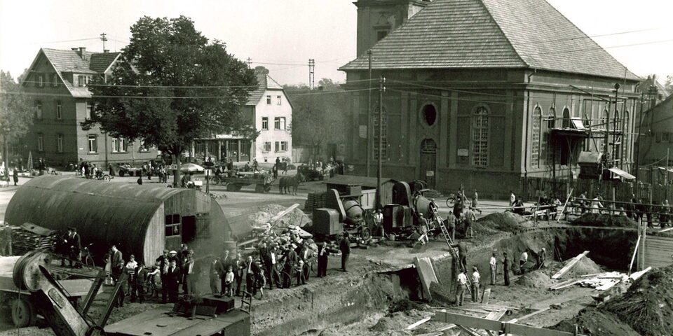 Der Rüsselsheimer Marktplatz im Jahr 1947. Zwischen Trümmerbeseitigung und Neuanfang dokumentiert dieses Foto den Wiederaufbau rund um die evangelische Stadtkirche in der frühen Nachkriegszeit.