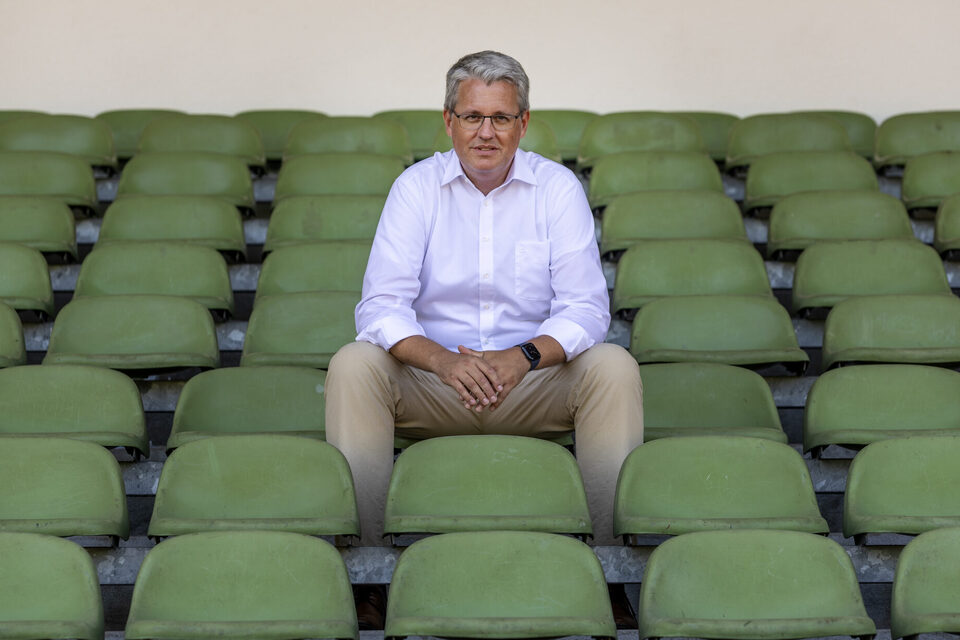 Oberbürgermeister Patrick Burghardt sitzt auf der Stadiontribüne.