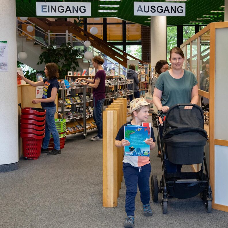 Eine Besucherin mit Kindern in der Stadtbücherei