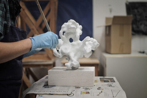 Foto: Hände arbeiten an einer Gips-Skulptur