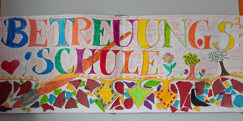 Banner an der Grundschule Hasengrund mit der gemalten Aufschrift "Betreuungsschule"