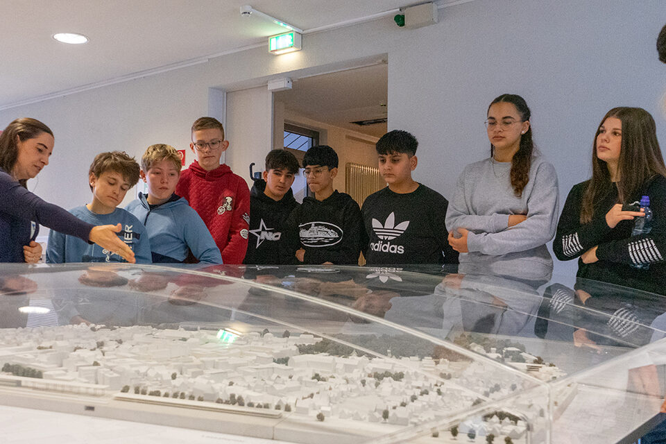 Jugendliche lassen sich während einer Führung durch das Rathaus ein Modell Rüsselsheims erklären