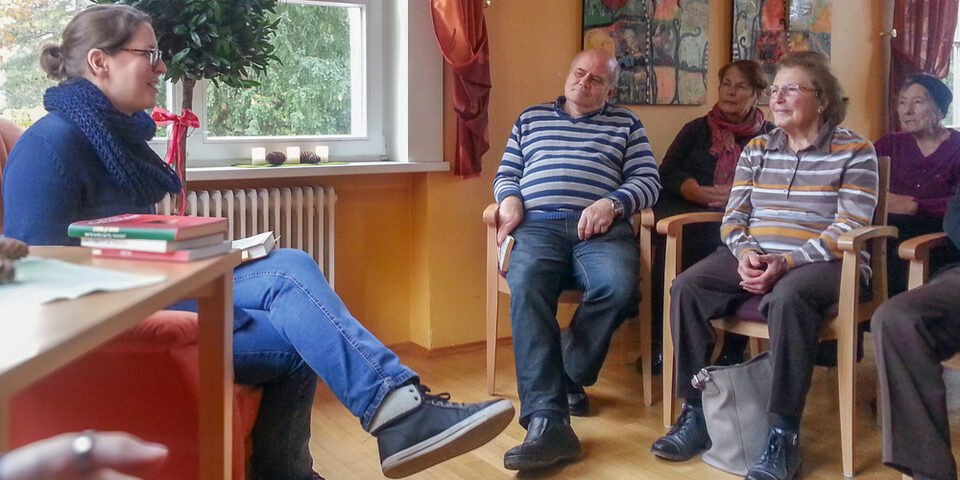 Ein Gruppengespräch im Haus der Senioren mit älteren Menschen und einer Mitarbeiterin