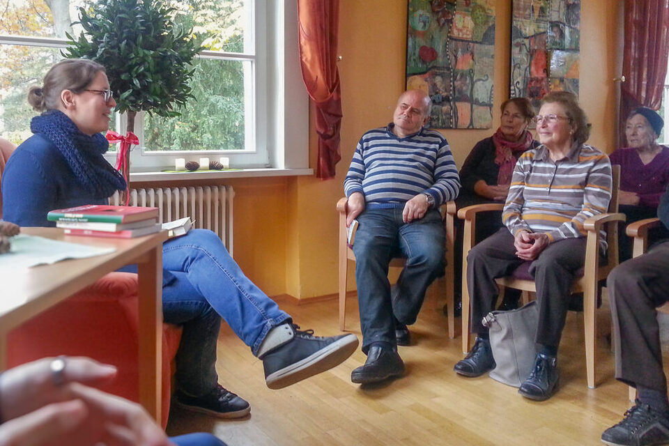 Ein Gruppengespräch im Haus der Senioren mit älteren Menschen und einer Mitarbeiterin