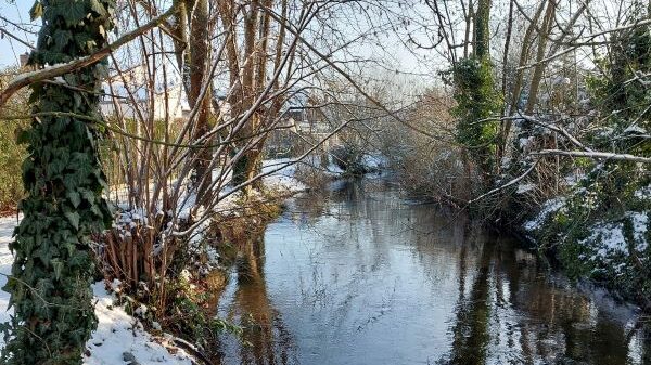 Schwarzbach im Winter mit verschneitem Ufer