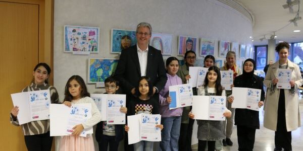 Oberbürgermeister Patrick Burghardt mit den Gewinnerinnen und Gewinnern des Rüsselsheimer Vorentscheides zum Kunstwettbewerb "Was Frieden für mich bedeutet" der Mayors for Peace.