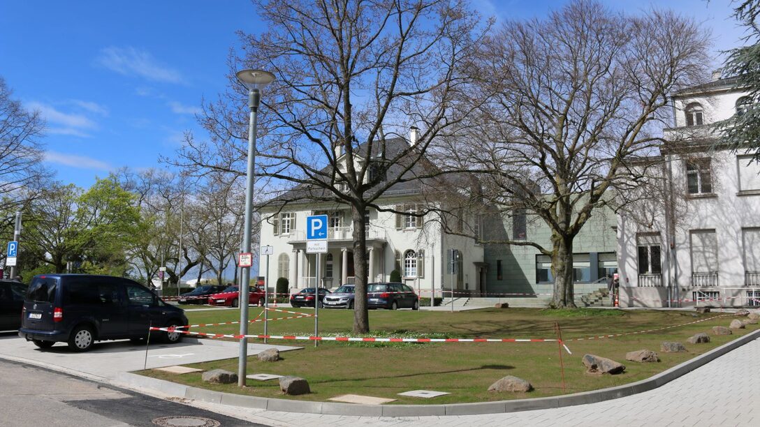 Sanierung der Freiflächen vor den Opelvillen, die Baustelle ist mit Flatterband abgetrennt. Im Hintergrund das Gebäude der Opelvillen.