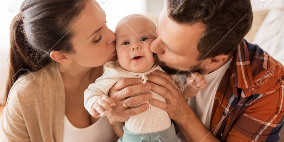 happy mother and father kissing baby at home